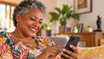 Smiling South African woman writing her online dating profile on her phone